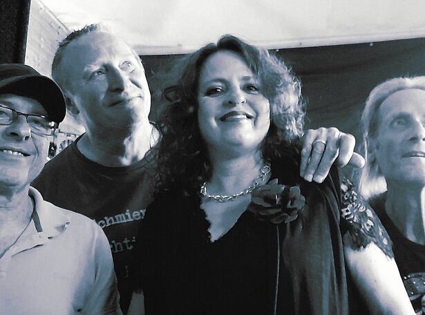 Band „inBetween“ in schwarz-weißem Bandfoto: vier Musiker eng nebeneinander, im Mittelpunkt eine Sängerin mit ausdrucksstarker Ausstrahlung – emotionale Rock- und Pop-Liveband mit starker Bühnenpräsenz.