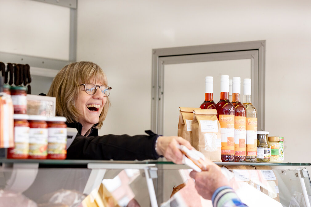 Eine lächelnde Verkäuferin auf dem Wochenmarkt.